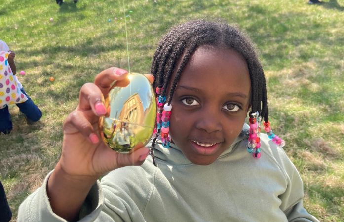 1st Grade student holding a golden egg